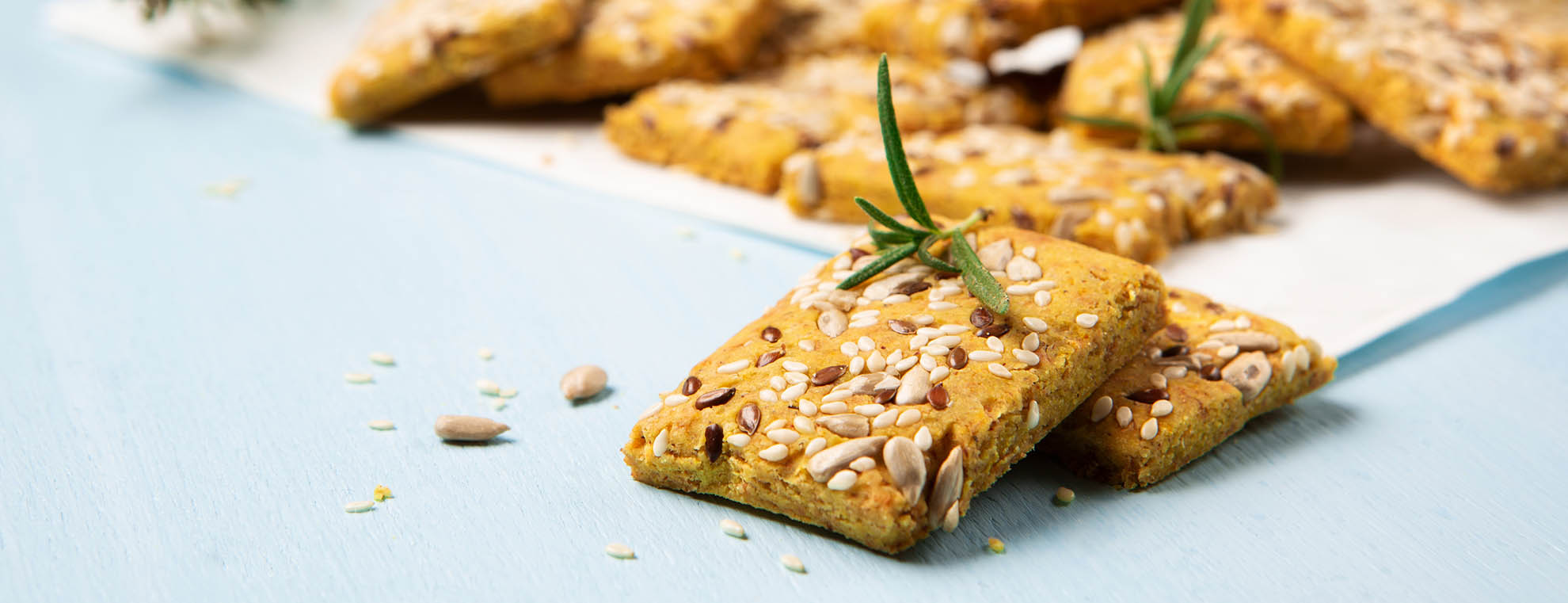 Gluten free Homemade Crackers and Rosemary for Appetizer on Blue Wooden Background.
